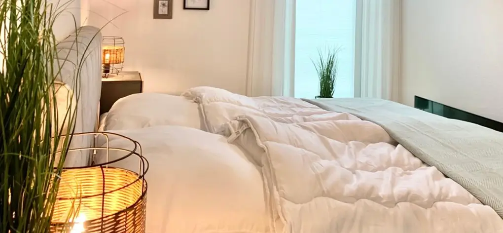 Schlafzimmer mit Doppelbett und Lampen auf Nachttischchen