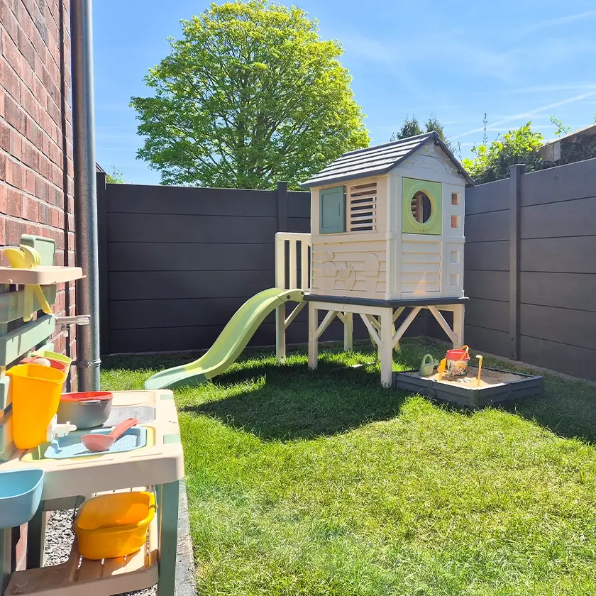 Spielturm für Kinder mit Rutsche und Sandkasten, Spielküche im Vordergrund