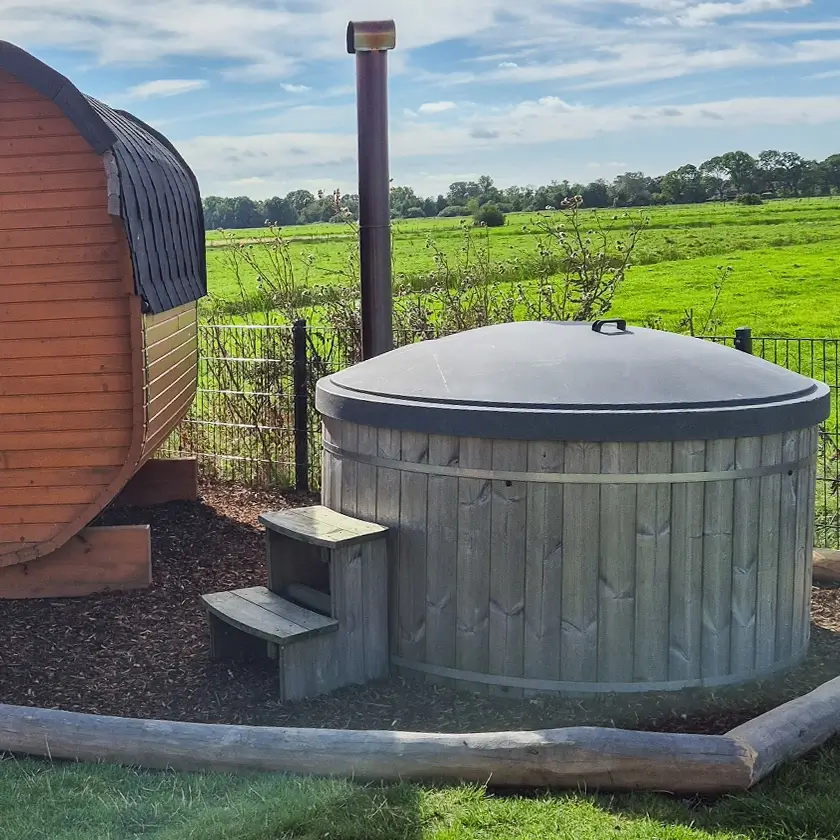 Abgedecktes Hotfass neben einer Gartensauna