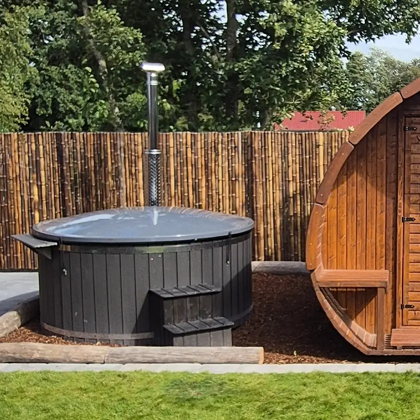 Abgedecktes Hotfass neben einer Gartensauna