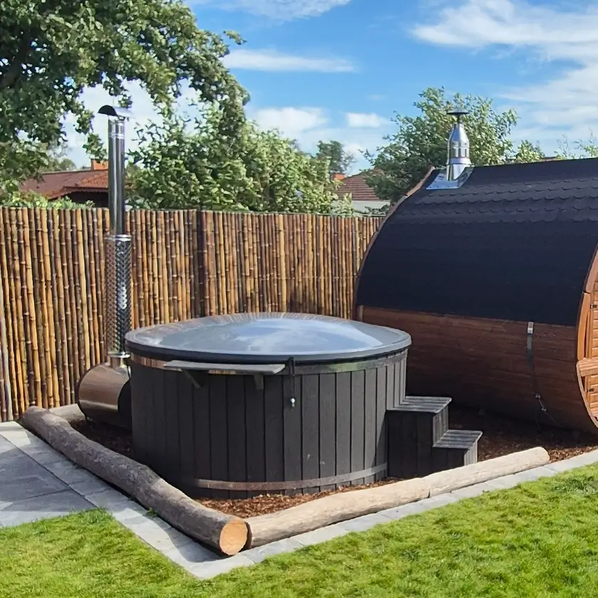 Abgedecktes Hotfass neben einer Gartensauna