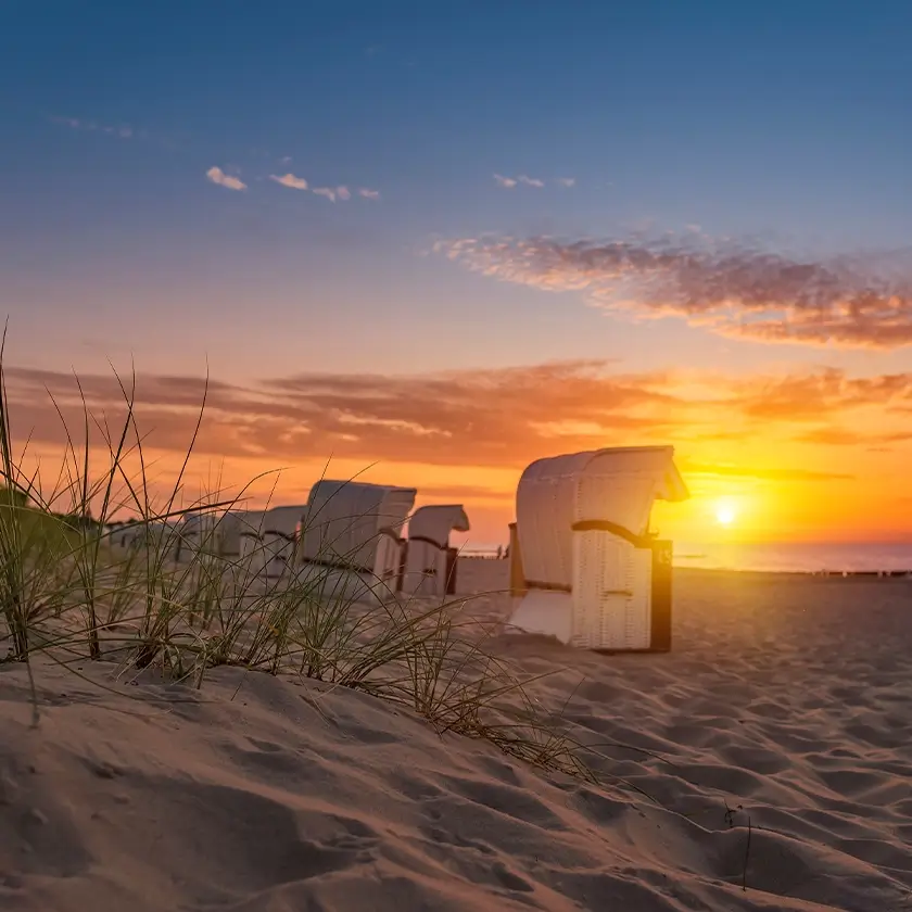 Sonnenuntergang am Strand, Strandkörbe und Gräser