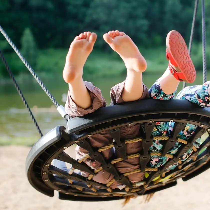 Kinder spielen auf einer runden Schaukel