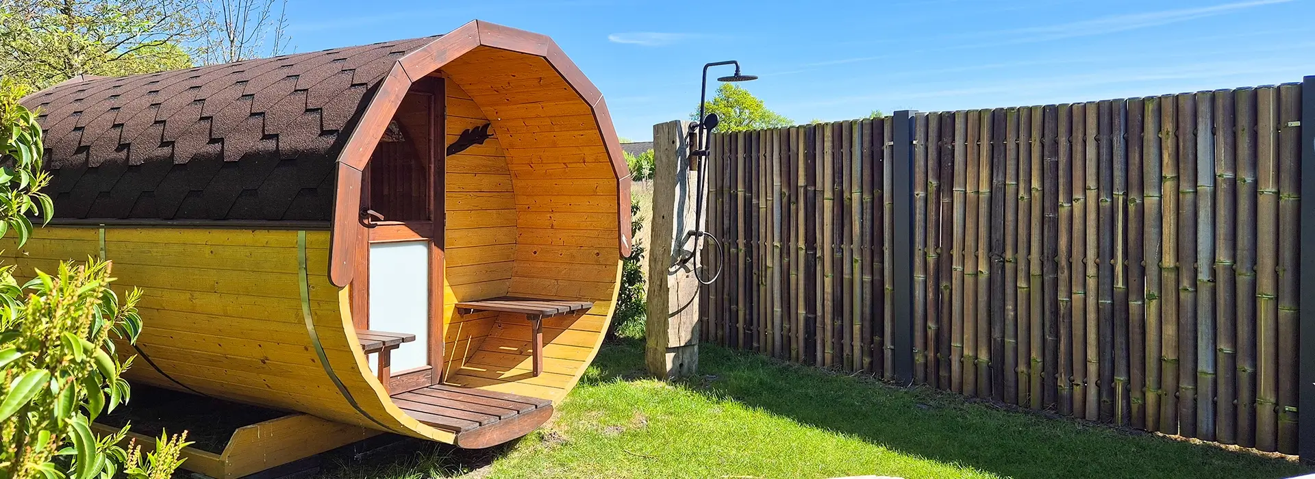 Holzsauna im Garten, mit Dusche daneben